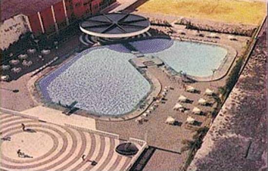 Vista aérea do conjunto de piscinas,  vestiários com chuveiros quentes e frios e hall para troca de roupas, e bar  em condição de atender inclusive com pequenos almoços (1975)